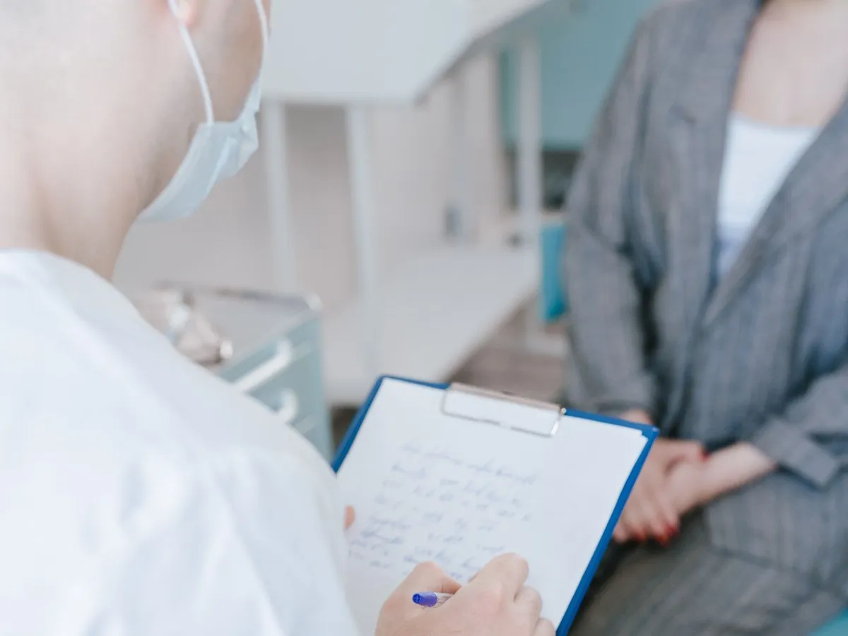 Medicinski radnik beleži informacije tokom razgovora sa pacijentkinjom
